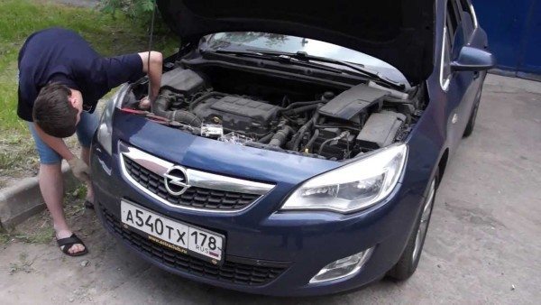 На фото: замена лампы ближнего света Opel Astra J может производиться даже на улице, главное – чтобы не шел дождь, так как влага губительно действует на все электрооборудование